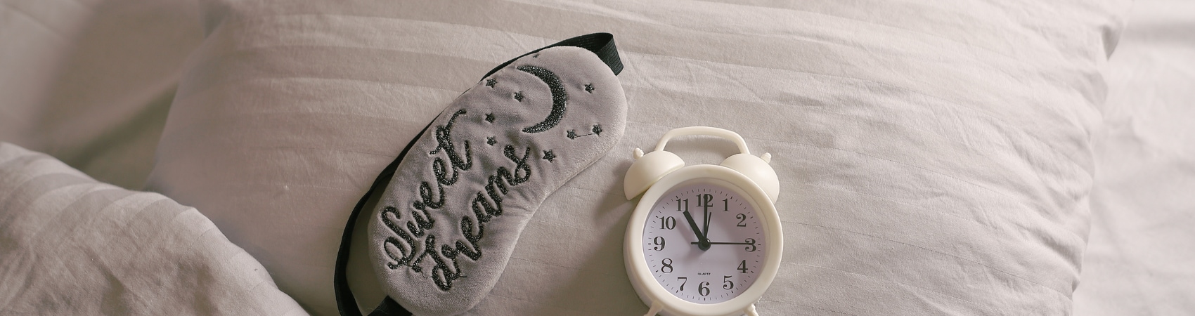 comfy bed with alarm clock and eye mask